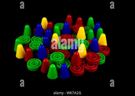 Coloured plastic board game tokens on a black background Stock Photo