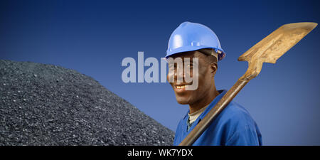 South African or African American coal miner with coal pile Stock Photo