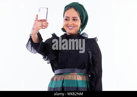 Happy young beautiful African Muslim woman taking selfie Stock Photo