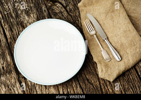 Table setting with vintage silverware or cutlery and empty plate on rustic wood. Top view. Stock Photo