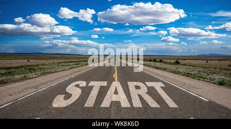 Start, new beginning concept. Text sign on a long straight highway in the american desert, blue cloudy sky background Stock Photo