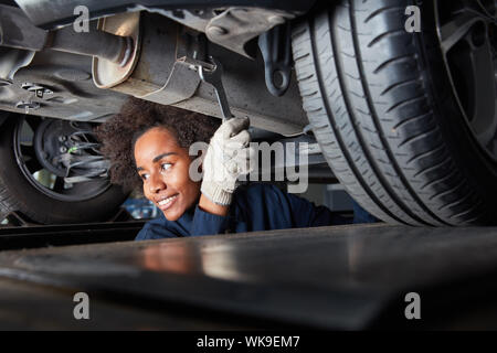 African woman is doing a training as a mechatronics engineer in auto repair shop Stock Photo