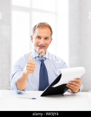 handsome businessman with papers showing thumbs up Stock Photo