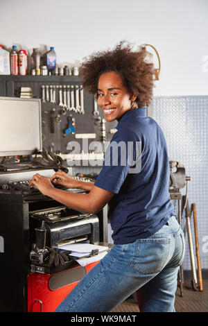 African woman at computer of auto repair shop is doing master craftsman training Stock Photo