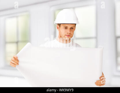 male architect looking at blueprint at home Stock Photo