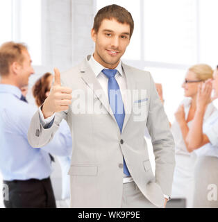 business and success - happy businessman showing thumbs up in office Stock Photo