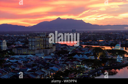 Burning red sky and clouds over Guning Serapi mountain at sunset in Kuching, Sarawak, Malaysia Stock Photo