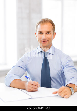 handsome businessman writing in notebook Stock Photo