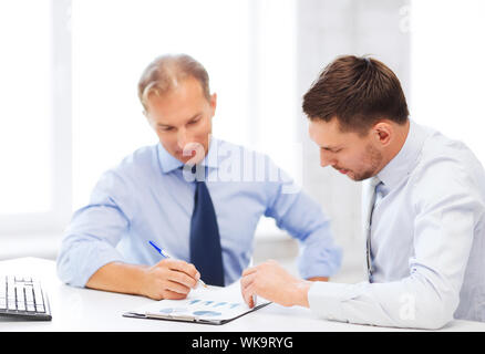 businesss concept - two businessmen discussing graphs on meeting Stock Photo