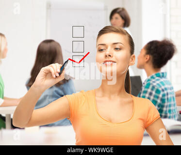 education and technology concept - student drawing checkmark on virtual screen Stock Photo