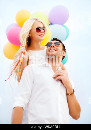summer holidays, celebration and dating concept - couple with colorful balloons Stock Photo