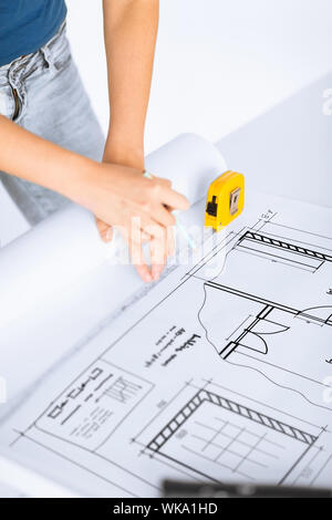 architecture and home renovation concept - architect drawing on blueprint using flexible ruler Stock Photo