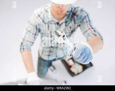 architect and home renovation concept - man with ladder, toolkit and spanner Stock Photo