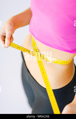 sport and diet concept - trained belly with measuring tape Stock Photo