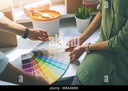 young couple choosing paint colur from swatch for new home interior Stock Photo