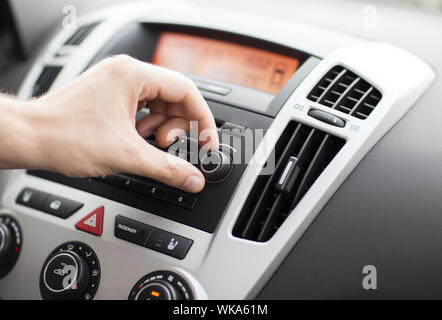 transportation and vehicle concept - man using car audio stereo system Stock Photo