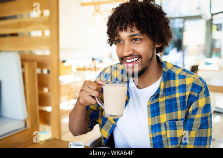 Happy handsome black man drinking coffee and smiling Stock Photo