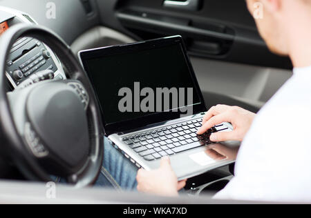 man using laptop computer in car Stock Photo