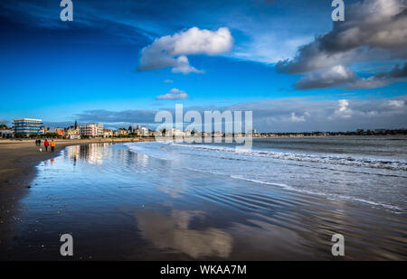 Royan (south-western France): beach of Grande Conche. Sky and clouds reflecting in the sea and the wet sand. In the background, buildings and villas o Stock Photo