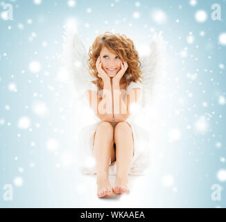 holidays and costumes concept - happy teenage angel girl Stock Photo