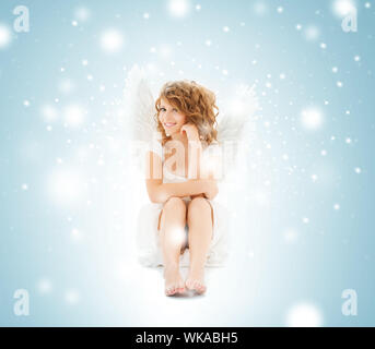 holidays and costumes concept - happy teenage angel girl Stock Photo