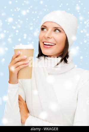 winter, people, happiness, drink and fast food concept - woman in hat with takeaway tea or coffee cup Stock Photo