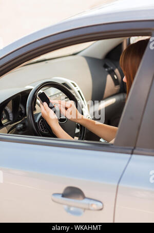 woman using phone while driving the car Stock Photo