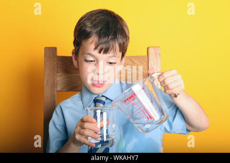 Extracting DNA from a Strawberry School strawberry DNA extraction Science Experiment at Home with Young Boy in School Uniform, UK Stock Photo