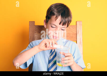 Extracting DNA from a Strawberry Science Experiment with Young Boy in School Uniform - strawberry DNA extraction Stock Photo