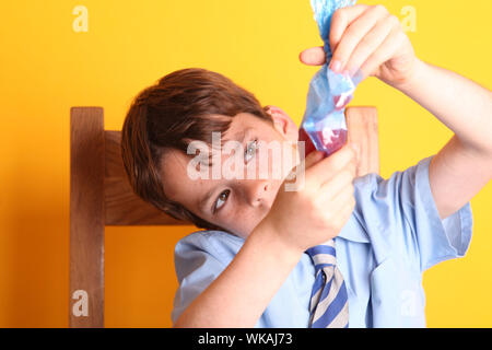 Extracting DNA from a Strawberry Science Experiment with Young Boy in School Uniform - strawberry DNA extraction Stock Photo