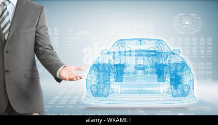 Businessman points hand on wire frame car. High-tech graphs at backdrop Stock Photo