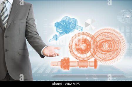 Businessman points hand on wire frame gears. High-tech graphs at backdrop Stock Photo