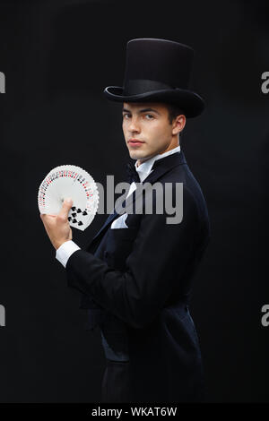 magician showing trick with playing cards Stock Photo