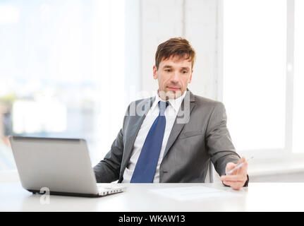 technology, business and office concept - puzzled businessman working with laptop computer and documents Stock Photo