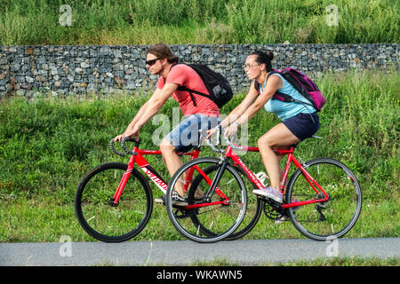 Man woman cycling without helmets on bike path Stock Photo