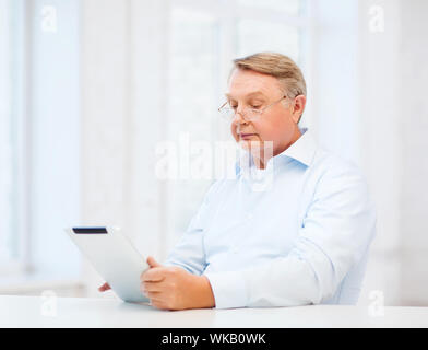 business, office, oldness, school and education concept - old man wearing eyeglasses with tablet computer at home Stock Photo