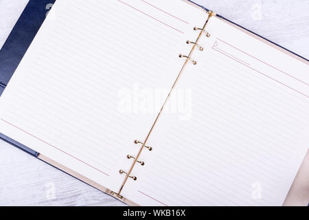 Opened leather notebook on white wooden background. Stock Photo