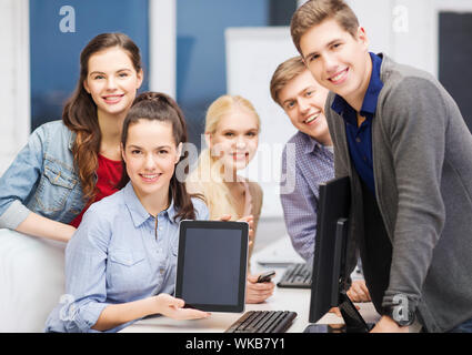 education, advertisement, techology and internet concept - group of smiling students with computer monitor and blank black tablet pc screen Stock Photo