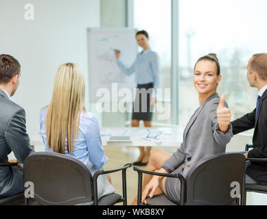 businesswoman with team showing thumbs up Stock Photo