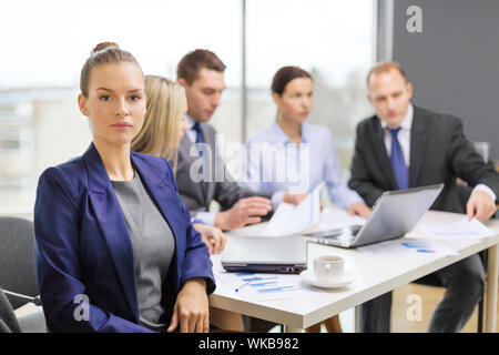 businesswoman in office with team on the back Stock Photo