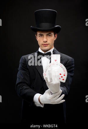 magician showing trick with playing cards Stock Photo