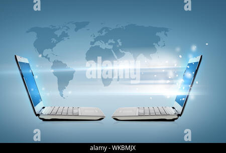 two laptop computers with world map hologram Stock Photo