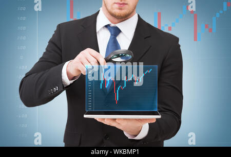 businessman hand holding magnifier over tablet pc Stock Photo