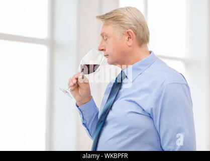 older man smelling red wine Stock Photo