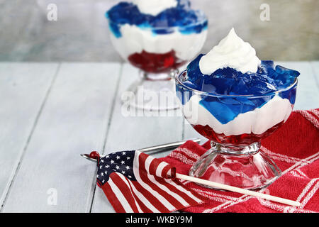 Gelatin layered dessert of cubes of red and blue jello with white fluffy whipped cream for the Fourth of July holiday. Shallow depth of field. Stock Photo