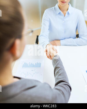 two calm businesswoman shaking hands in office Stock Photo