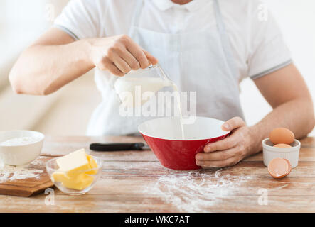 close up of male hand pouring milk in bowl Stock Photo