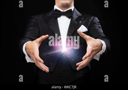 magic, performance, circus, show concept - magician in top hat showing trick Stock Photo
