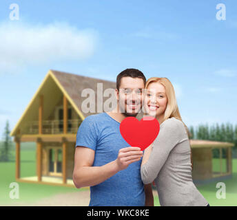 smiling couple holding big red heart Stock Photo