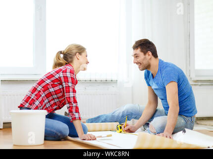 smiling couple measuring wallpaper Stock Photo